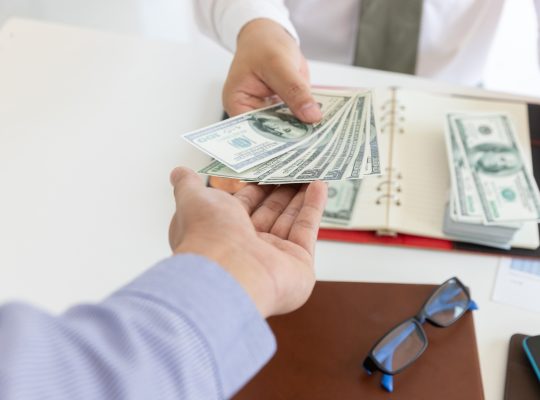 Business and finance concept, Hand of a businessman giving money to his partner.